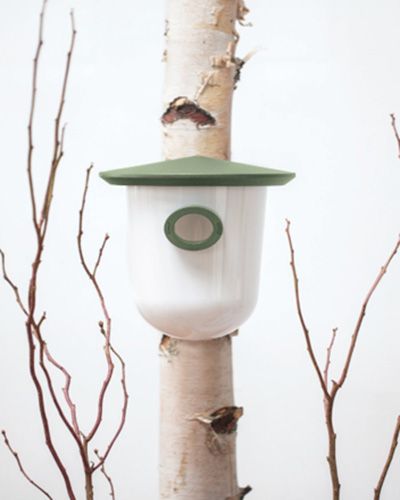 Nichoir moderne suspendu sur un tronc d'arbre, avec un toit vert.